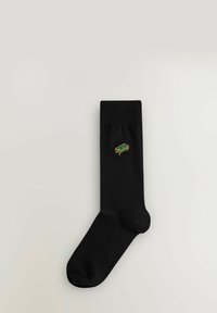 Čierne bavlnené ponožky s rebrovaným lemom, na boku so zlatozeleným vyšitým motívom biliardového stola.