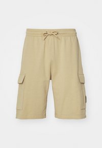 Beige cotton cargo shorts with an elastic waistband, drawstring, and side pockets. Smooth texture and knee-length design.