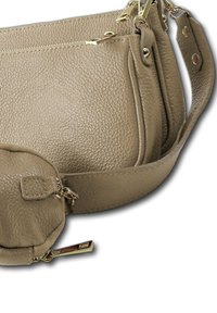 Beige textuur leren schoudertas met gouden ritsen en hardware, voorzien van meerdere ritscompartimenten en een verstelbare schouderband.