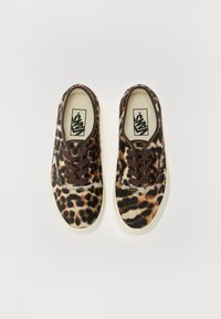 Buty w panterkę z miękką teksturą, brązowymi sznurowadłami i białymi gumowymi podeszwami, zaprojektowane w klasycznym stylu sneakersów.