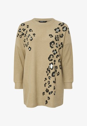 Beige pitkähiha, jossa on mustia ja harmaita leopardilaikkoja ja pieniä helmiä koristeena edessä ja vasemmalla olkapäällä.