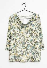 Haut fleuri avec un col bénitier, manches 3/4, réalisé en tissu léger dans des tons verts, jaunes et gris, présentant un design fluide.