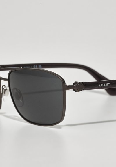 Ochelari de soare Burberry cu lentile dreptunghiulare de culoare gri închis, rame metalice subțiri și brațe cu accente negre, având un mic logo și detalii distinctive.