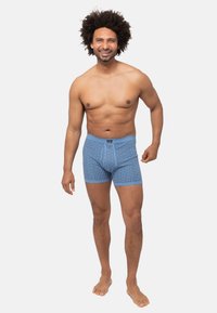 Boxer in cotone blu con stampa testurizzata, vita elastica e design aderente, con righe verticali di colore contrastante.
