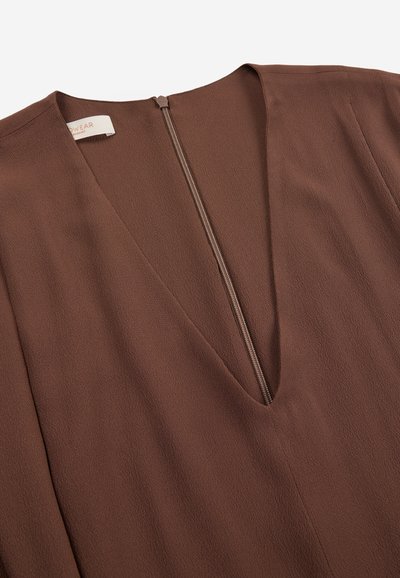 Braunes Kleid aus strukturiertem Stoff mit tiefem V-Ausschnitt und mittig verlaufendem Rückenreißverschluss.