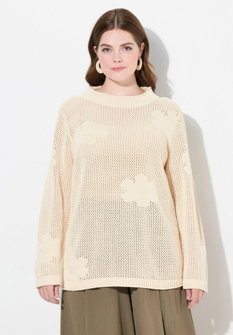 Maglione lavorato a maglia color crema con una vestibilità ampia, caratterizzato da un motivo floreale, colletto a costine e maniche lunghe. Design a trama aperta e testurizzata.