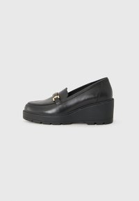 Mocassins noirs à semelle compensée en cuir lisse avec un bout arrondi, comportant un détail décoratif en métal doré à l'avant.