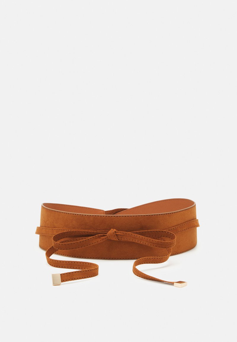 Brown suede belt with a smooth texture. Features a tied knot and slender end with a gold accent. Designed for a fitted silhouette.