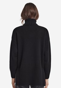 Sort turtleneck sweater med ribbet design ved kraven og kanten, brede ærmer og en afslappet pasform, lavet af blødt materiale.