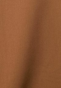 Tissu marron uni avec une surface tissée lisse, légèrement texturée et des variations subtiles de nuances.
