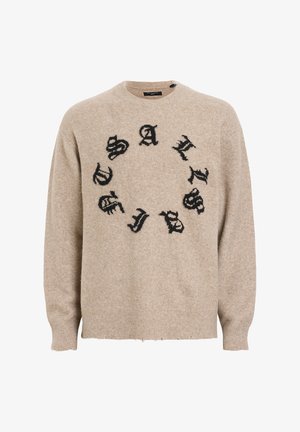 Beige villapaita pyöreällä kaula-aukolla, jossa on mustaa tekstiä ympyräkuviossa. Teksti näyttää kuluneelta, ja hihansuissa ja helmassa on ribbireunat.