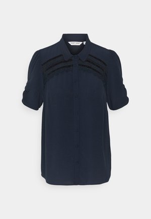 Blouse bleu marine à manches courtes avec fermeture à boutons sur le devant, détails en dentelle sur la poitrine et col classique.