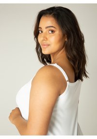 Witte mouwloze top met schouderbanden, met een zachte textuur en een soepel draperingsontwerp, getoond op een model vanuit de zijaanzicht.