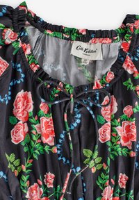 Rochie florală neagră cu trandafiri roz și frunze verzi, cu un decolteu strâns și detalii cu șnur. Etichetată "Cath Kidston, Londra."