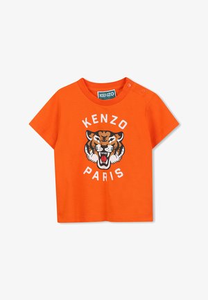 Orange cotton t-shirt featuring a tiger graphic and "KENZO PARIS" text. Short sleeves with two snap buttons at the shoulder for easy dressing.