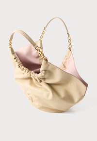 Μπεζ τσάντα χειρός από απαλό δέρμα με μαζεμένη κορυφή, εσωτερικό σε ανοιχτό ροζ και κοντές λαβές με διακοσμητικά χρυσής αλυσίδας, εμφανίζεται σε λευκό φόντο.