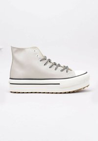 Sneaker bianco alto con suola spessa a piattaforma, occhielli neri e lacci bianchi e neri, mostrato di profilo su uno sfondo neutro.