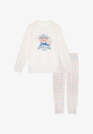 Langärmeliges cremefarbenes Oberteil mit Bärenmotiv und dem Text "APRES SKI LOVER", kombiniert mit gemusterten Schlafanzughosen mit Cocktails und Schneeflocken.