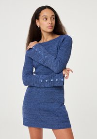Blauwe gebreide jurk met een aangesloten silhouet, gestructureerde stof, lange mouwen en knoopdetails bij de manchetten.