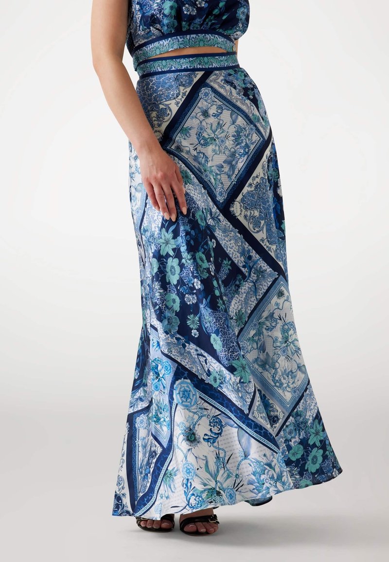 Jupe longue imprimée de fleurs marine et bleu clair. Fabriquée en tissu lisse, elle présente des sections de motifs diagonaux et une taille ajustée.