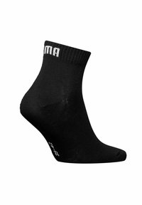 Black ankle socks made of soft fabric, featuring a ribbed cuff. A white logo is displayed on the outer side, with a smooth texture.