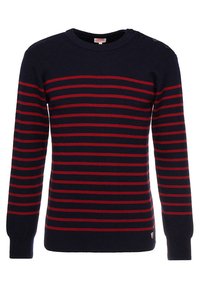 Granatowy sweter robiony na druty w poziome czerwone paski, okrągły dekolt i detal z trzema guzikami na ramieniu. Tkanina wydaje się gładka i fakturowana.