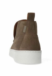Bruine suede enkellaars met een gestructureerde afwerking en witte rubberen zool. Beschikt over een treklus aan de hielen en een gestikte accent langs de basis.