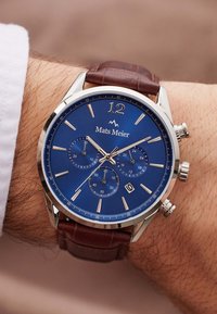 Silberner Edelstahl-Uhren mit blauem Zifferblatt, drei Hilfszifferblätter, braunem Lederarmband, Datumsanzeige, polierten Akzenten und numerischen Stundenmarkierungen.