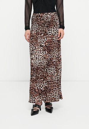 Leopardikuvioinen maksihame yhdistetty mustiin, niititettyihin nilkkaremmeihin sopiviin teräväkärkisiin korkokenkiin ja mustaan läpikuultavaan pitkähihaiseen paitaan.