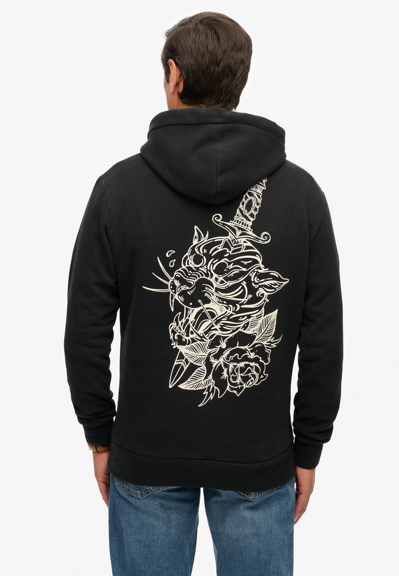 Felpa nera con cappuccio con un grande motivo bianco che raffigura il volto di un gatto e una spada, arricchita da rose e foglie, realizzata in tessuto morbido e strutturato.
