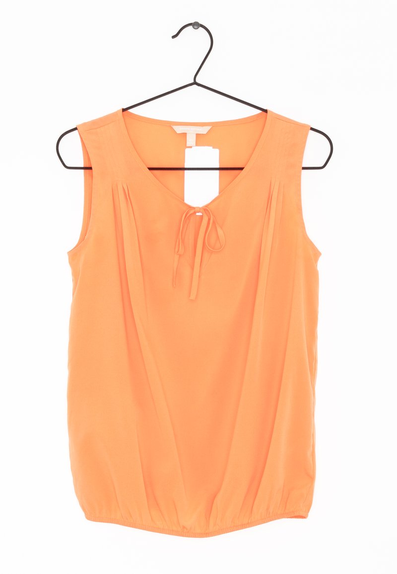 Orange sleeveless blouse with a v-neckline, tie at the front, pleated detailing, and a gathered hem, made from soft fabric. Hangs on a black hook.