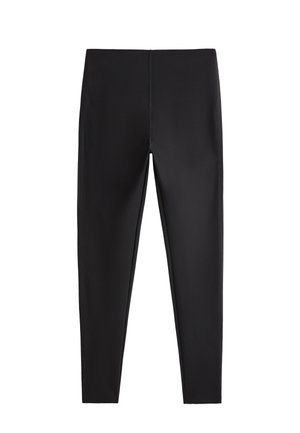 Zwarte leggings van rekbaar materiaal, met een naadloos ontwerp en een aansluitende pasvorm, zonder zichtbare metalen delen of patronen.