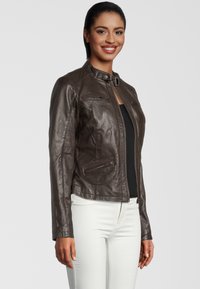 Bruine leren jas met een ritssluiting aan de voorkant, hoge kraag en meerdere ritszakken. Heeft een getailleerd ontwerp en een gladde textuur.