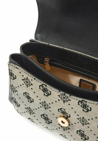 Sac à main en toile beige avec imprimé logo noir, fermeture à pression dorée et accents en cuir noir. Comprend une poche zippée à l'intérieur.
