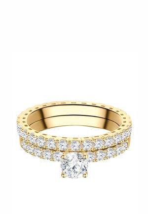 Anillo de oro con doble fila de pequeños diamantes y un diamante redondo más grande en el centro sobre un fondo blanco.