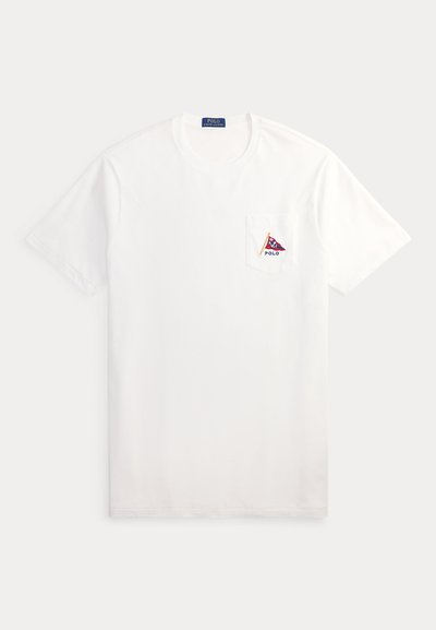 Απλό λευκό κοντομάνικο T-shirt με μικρή εμπρόσθια τσέπη που διαθέτει λογότυπο κόκκινου και μπλε σημαίας και τη λέξη Polo στην τσέπη.