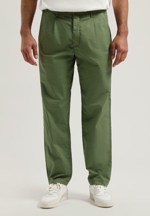 Groene, lichte broeken met een gladde textuur, met een recht model en plooien aan de voorkant. Gekenmerkt door witte sneakers.