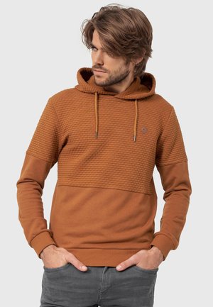Braune Textur-Hoodie mit einem einfarbigen unteren Abschnitt, Kordelzügen und einem kleinen Logo auf der Brust. Das Material wirkt weich und lässig.