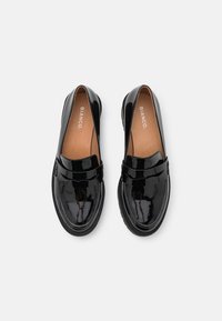 Schwarze Lackleder-Slipper mit runder Zehenform, ausgestattet mit einem vorderen Riemen und einer strukturierten Gummisohle. Das Innenfutter ist in Beige gehalten und trägt das Branding.