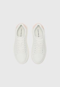 Sneakers bianchi con tomaia in pelle liscia, punta rotonda e rifiniture rosa sul tallone. Presentano lacci bianchi e un colletto imbottito. Suola texturizzata.