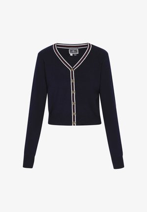 Námořnický svetr s dlouhými rukávy, ve tvaru V a zlatými knoflíky. Obsahuje bílé a červené pruhované detaily kolem límce a knoflíkové légy.