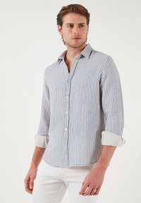 Cămașă în dungi, bleu deschis și crem, fabricată dintr-un material respirabil. Prezintă închidere cu nasturi, guler și mâneci suflecate. Design slim fit.