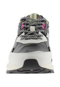 Scarpa sportiva in bianco e nero con superficie testurizzata, riflettente materiali. Presenta lacci rosa e verdi, linguetta imbottita e suola in gomma.