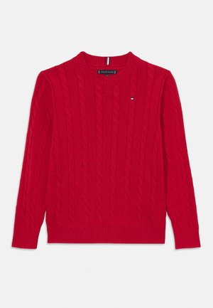 Rød kabelstrikket genser med rund hals. Har ribbestrikkede mansjetter og kant, samt en liten logoaccent. Laget av myk, teksturert stoff.
