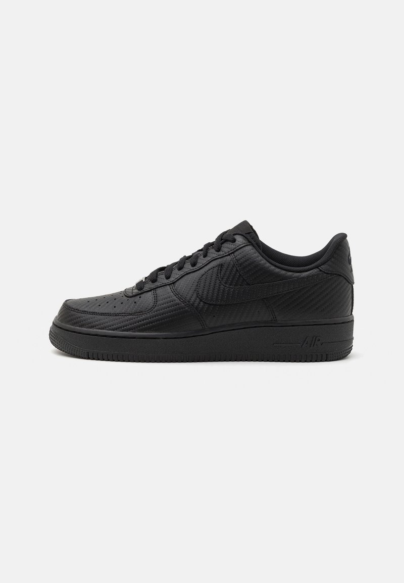 Black sneaker featuring a smooth upper with perforated details, round toe, lace-up design, textured accents, and a rubber sole.