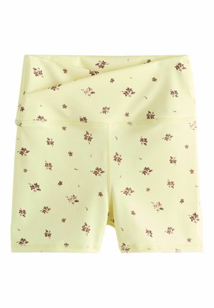 Yellow high-waist bike shorts with small brown floral print, folded waistband, and visible stitching along seams.