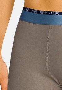 Graue Herren-Boxershorts aus Baumwolle mit einem hellblauen elastischen Bund, der "CR7" und "CRISTIANO" in marineblauer Schrift zeigt. Glatte Textur, körpernaher Schnitt.