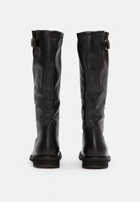 Bottes en cuir noir jusqu'aux genoux avec une texture lisse, dotées d'un accent de boucle sur le côté et d'un talon empilé. Design élégant et structuré.