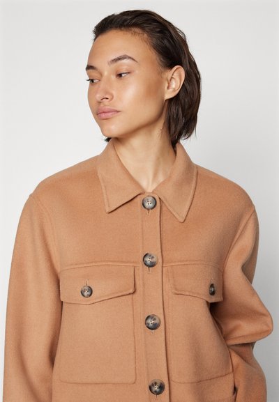 Braune Wollmischungjacke mit Kragen, zwei Fronttaschen und dunklen Knöpfen; weiche Textur und lässige Passform.