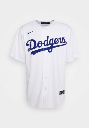 Camiseta de béisbol blanca con letras azules "Dodgers", cierre de botones y mangas cortas, hecha de tejido transpirable. Presenta el logo de Nike en el hombro.